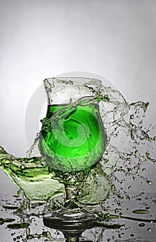 Splash in glass of green alcoholic cocktail drink