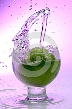 Splash in glass. Green apple