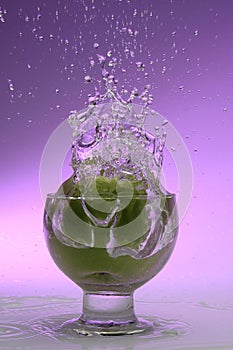 Splash in glass. Green apple