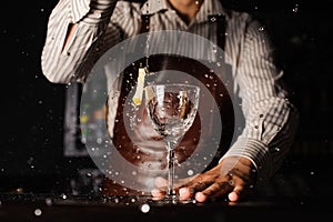 Splash in a glass with lemon barman on background