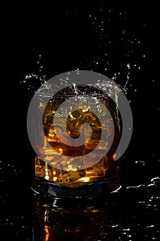 splash from glass of scotch whiskey with ice