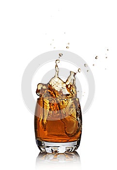 Splash in glass of scotch whiskey with ice cube