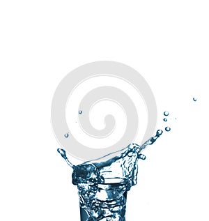 Splash in a glass on white isolated background. Vodka on an old wooden table as detailed close-up shot, Hand over glass