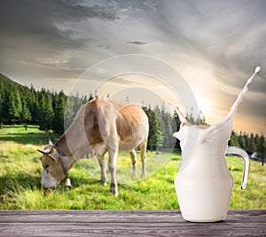 Splash in jug of milk on beige cow background