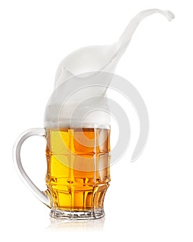Splash of light beer in faceted mug