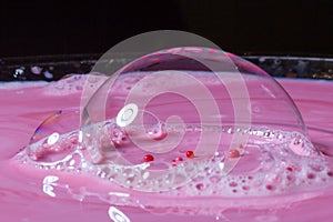 Splash of milk drop in pink color under the buble.