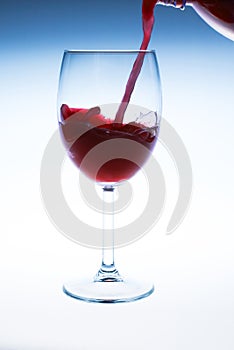 Splash red wine glass against a white background