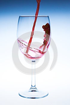 Splash red wine glass against a white background