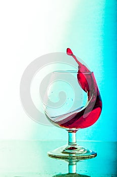 Splash of red wine in a glass. White Background