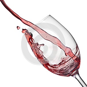Splash of red wine in wineglass on white