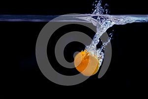 Splash of tangerine in water. freshness concept