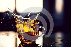 Splash of tea in the sun reflection