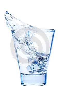 Splash of water in an elegant glass with ice isolated