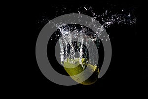 A splash of water from a fallen avocado on a black background