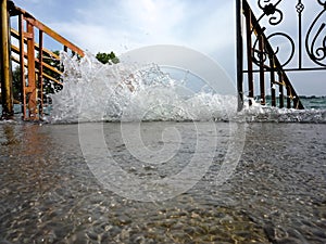 Splash of water on the lake shore near the stairs