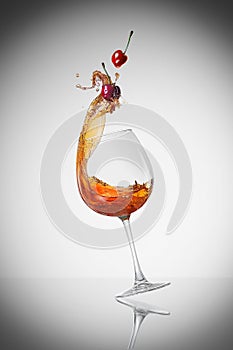 Splashed wine with cherry in the wineglass.