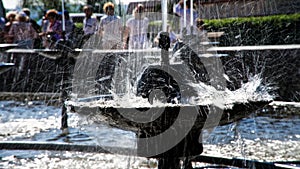 Splashes of the city fountain in hot summer weather. Long exposure. Contrast and close-up