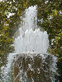 Splashes and jets of the fountain in the city park. A fountain with splashes and drops of water works.