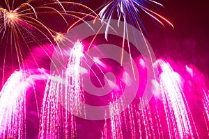 splashes of pink bright beautiful fireworks in the night sky on