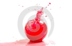 Splashes of red liquid in a glass globular vase