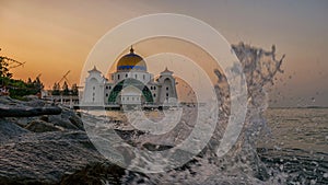 Splashes at Straits Mosque of Malacca during sunrise.