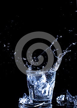 Splashes of water. Falling ice cubes into a glass of water