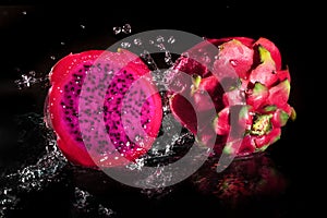 Splashing fresh pitaya falling in water Tropical dragon fruit or pitaya on Black background