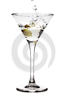 Splashing olive into a martini glass