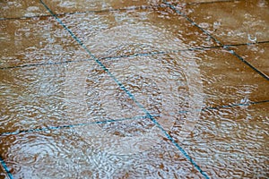 Splashing rain drops on patio tile floor