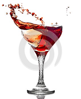 Splashing red wine in crystal wineglass.