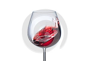 Splashing red wine in a glass goblet on white background