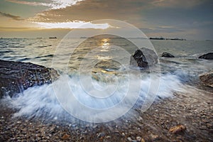 splashing sea water and beautiful sunset sky at laem chabang chonburi eastern of thailand