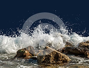 Splashing sea water on rocks isolated on a dark background