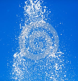 Splashing water from a fountain against the blue sky