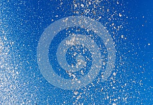 Splashing water from a fountain against the blue sky