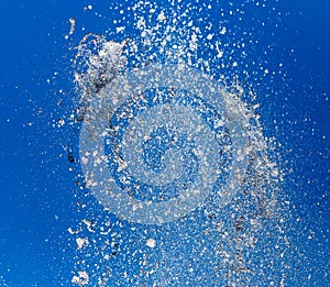 Splashing water from a fountain against the blue sky