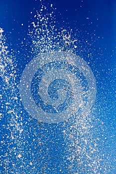 Splashing water from a fountain against the blue sky