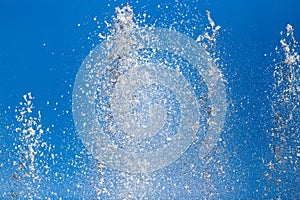 Splashing water from a fountain against the blue sky