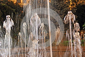 Splashing water from fountain. water jets in evening city