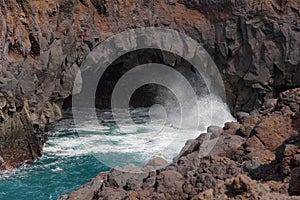 Splashing water over the rocks in Los Hervideros, Lanzarote, Spain