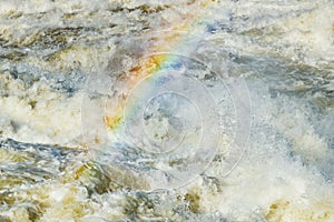 Splashing water waves with rainbow on the fast river