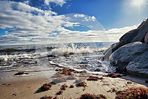 splashing waves on a sandy beach with rocks