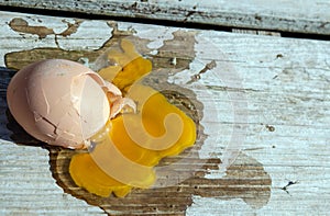 Splattered egg on a wooden deck.