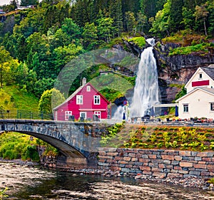 Splendid summer view with Large, popular waterfall Steinsdalsfossen on the Fosselva River. Picturesque morning scene of  village