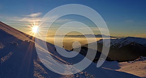 Splendid sunset. Winter mountain landscape. Sun, snow and hikers at high altitude - Ciucas Mountains, landmark attraction, Romania