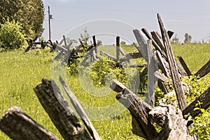 Split cedar rail fence curves through fields in a rural community on a farm