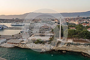 Split, Croatia - Aug 13, 2020: Aerial drone shot of port lighthouse by rock cliff in sunset hour