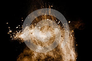 Split debris of stone exploding with brown powder against white background