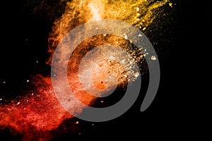 Split debris of stone exploding with orange red powder splash against black background