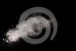 Split debris of stone exploding with white powder against black background